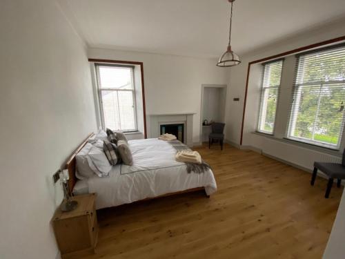 瑟索Manor House Hotel的一间卧室配有一张铺有木地板的白色床单。