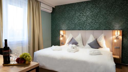 兰什克龙Hotel Karolina的一间卧室设有一张白色大床和绿色的墙壁