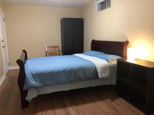 多伦多Spacious 2 Bedroom guest suite的一间卧室配有一张带蓝色床单的床和梳妆台。