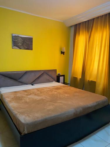 突尼斯梅彻珀勒酒店的一间卧室设有一张黄色墙壁的大床
