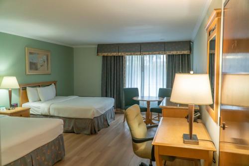 弗雷斯诺皮卡迪利酒店的酒店客房设有两张床和一张桌子。