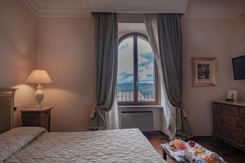 古比奥杜卡勒酒店的一间卧室设有一张床和一个大窗户