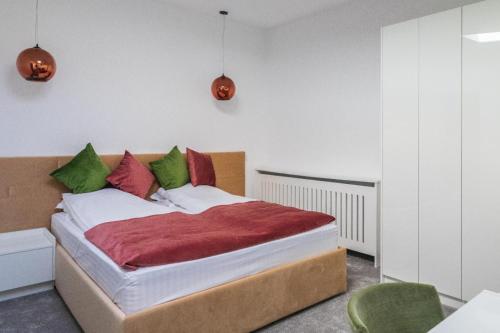 布拉索夫Casa Andreea的一间卧室配有红色和绿色枕头的床