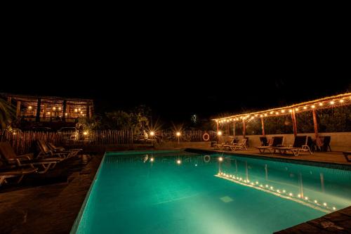卢那欢纳拉宫费昂扎酒店的夜间游泳池,配有椅子和灯