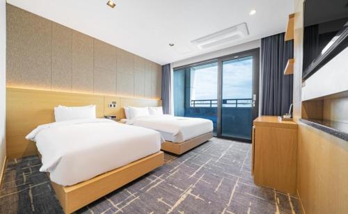 束草市Sea Cruise Hotel的酒店客房设有两张床和电视。