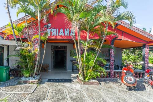帕朗卡拉亚OYO 2527 Hotel Triana的一间位于酒店前方的棕榈树餐厅