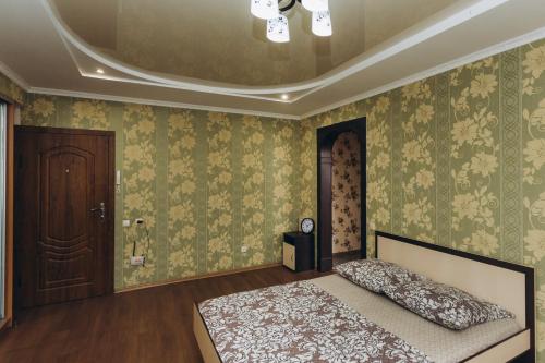 苏梅Apartments Faraon neer Manufaktura的一间设有床铺的卧室,位于一个绿色壁纸的房间