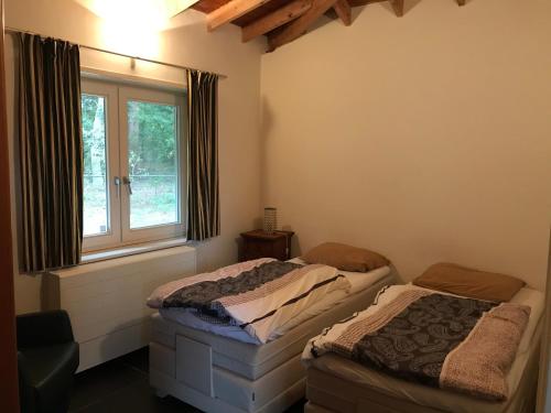 伦德Het Atelier, ruime vrijstaande vakantiewoning 200m2 voor maximaal 8 personen的带窗户的客房内设有两张单人床。