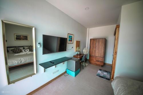 Ban BuaLotus Lake View的一间卧室配有电视、书桌和床。