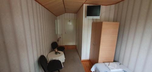 Rahinge库尔旅馆的小房间设有桌椅和电视