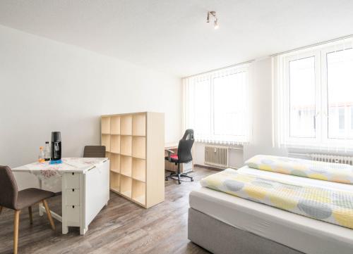 阿伦Apartmenthaus Aalen的一间卧室配有一张床和一张书桌