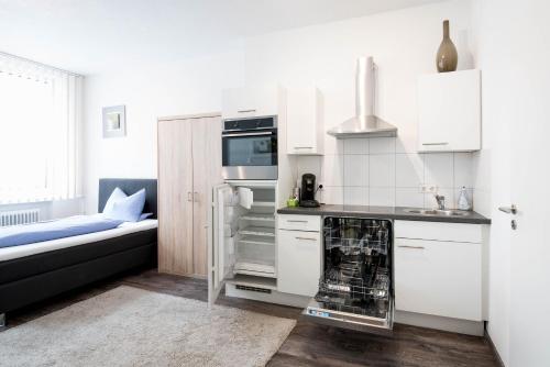 阿伦Apartmenthaus Aalen的厨房配有白色橱柜和炉灶烤箱。