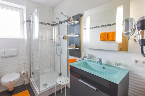 巴特克罗青根伊甸酒店的一间带水槽、淋浴和卫生间的浴室