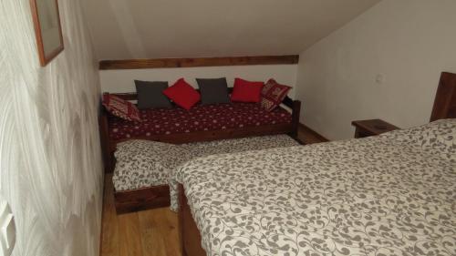 莱索尔Les Orres 1800 Appartement vue exceptionnelle avec parking privatif的一间卧室配有两张带红色和黑色枕头的床