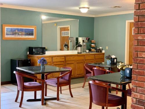 麦卡莱斯特Candlelight Inn & Suites Hwy 69 near McAlester的一间带两张桌子的用餐室和一间厨房