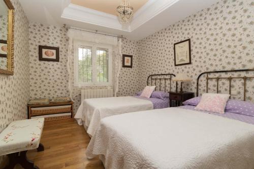Villa en Rioja-Alavesa Juncalvera的一间卧室设有两张床和窗户。