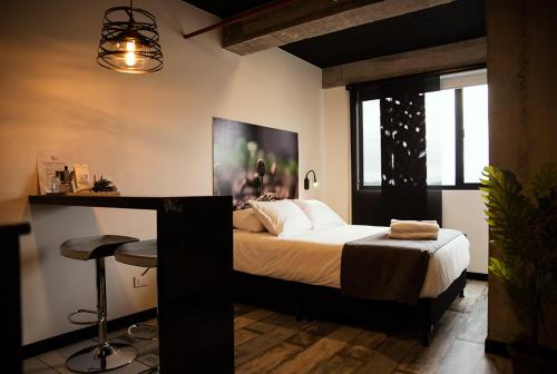马尼萨莱斯The Coffee Club的一间卧室配有一张床和一张桌子及凳子