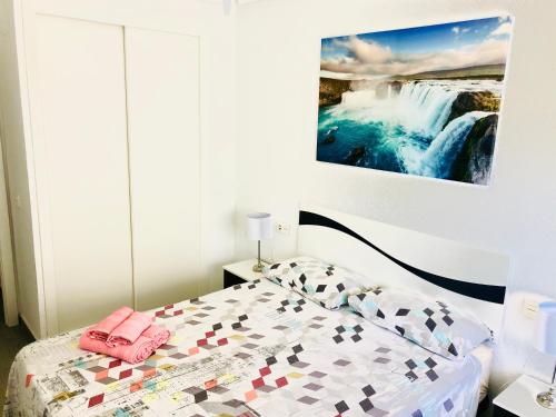 圣波拉Apartamento Santa Pola"The Guitar" 300 m de la playa的一间卧室配有一张床,享有瀑布的景色