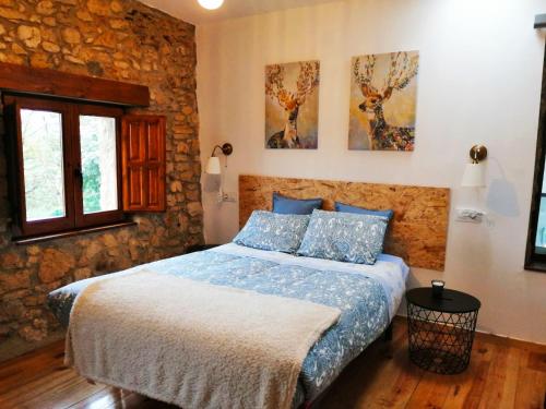 奥维多El llagar - Sagasta Rural Oviedo的卧室配有一张石墙床