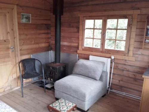 弗吕济Arngrimslundur log cabin - cabin 3的小屋内带炉灶和椅子的房间