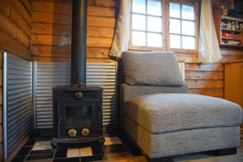 弗吕济Arngrimslundur log cabin - cabin 3的小屋内带炉灶和椅子的房间