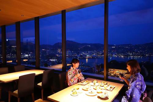长崎Ooedo Onsen Monogatari Nagasaki Hotel Seifu的坐在餐厅桌子上的两名妇女