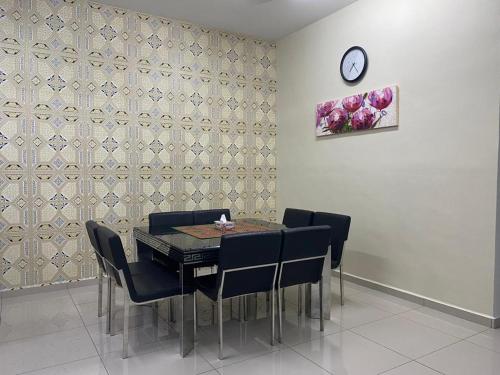 马六甲Homestay ayer keroh mitc的一间带桌椅和时钟的用餐室