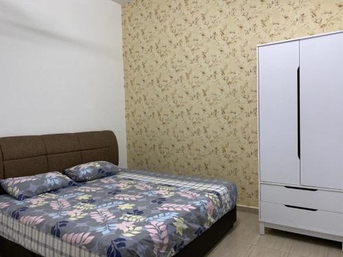 马六甲Homestay ayer keroh mitc的一间卧室配有床和白色梳妆台