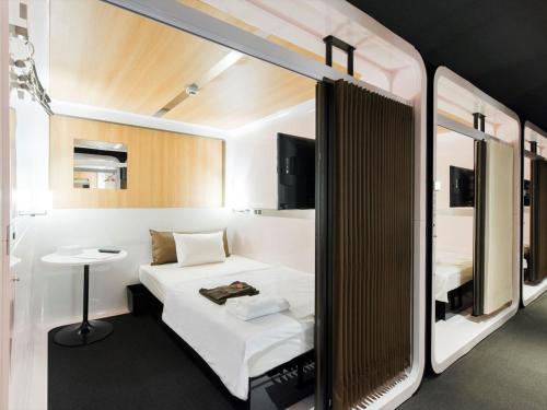 俱知安町TORIFITO HOTEL&POD NISEKO的小房间设有一张床和一张小桌子