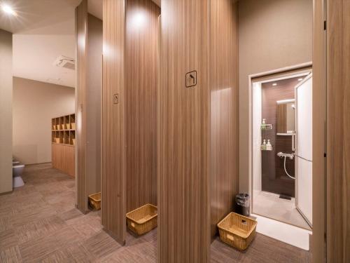 俱知安町TORIFITO HOTEL&POD NISEKO的一间带卫生间的浴室和一些木墙