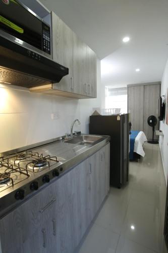 麦德林New Studio Apartment for Two的厨房配有水槽和炉灶 顶部烤箱