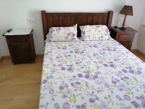 布罗托Completo Broto的一张带花卉棉被和两个枕头的床