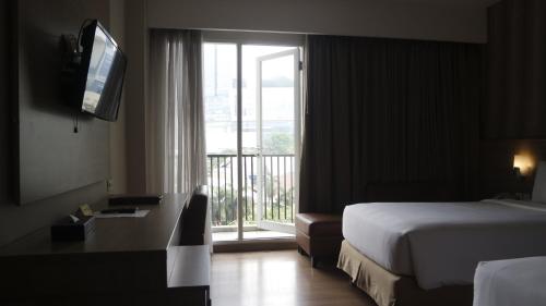 雅加达艾亚柯套房酒店的酒店客房设有一张床和一个阳台窗户