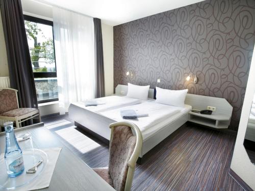 乌克拉特兰德斯科奈其酒店的酒店客房带一张床、一张桌子和椅子