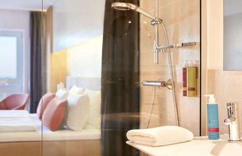 圣彼得奥尔丁斯特兰德古特度假酒店的浴室旁设有玻璃门淋浴