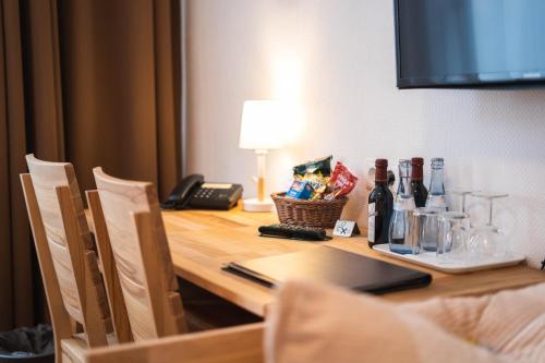 斯图加特豪斯特格潘森酒店的一张桌子、一部电话和一瓶葡萄酒