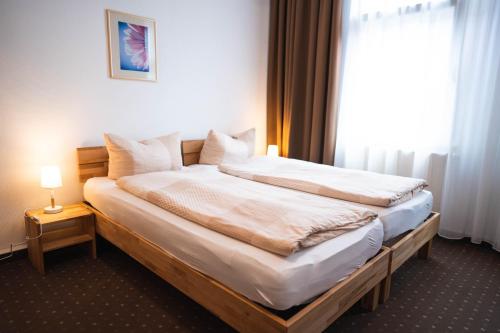 斯图加特豪斯特格潘森酒店的窗户的酒店客房内的一张床位
