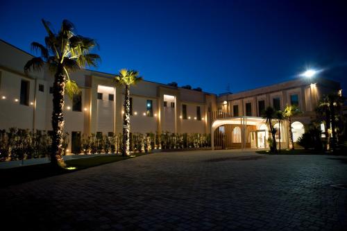 莱切莱切艺术和公园酒店的棕榈树和灯光的庭院