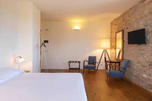 SantʼEgidio罗坎达天堂旅馆的一间卧室设有一张床和砖墙