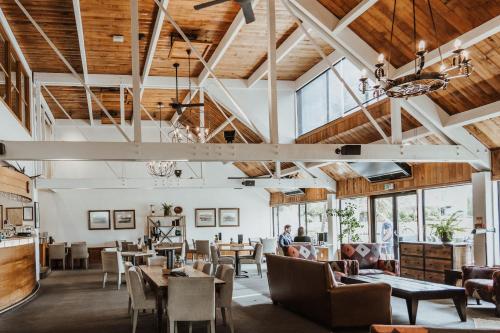 瓦纳卡Edgewater Hotel的餐厅设有木制天花板和桌椅