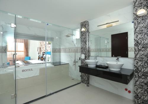 土龙木市米拉精品酒店的一间带两个水槽和玻璃淋浴间的浴室