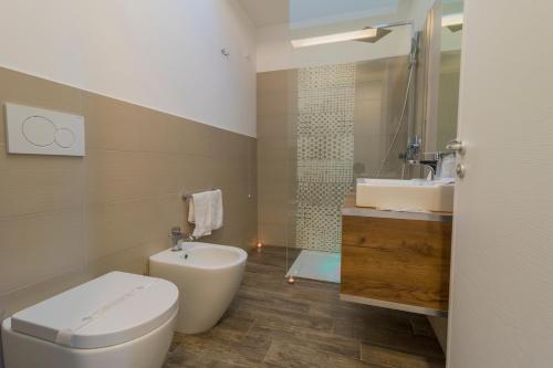 托雷圣乔万尼乌Villaggio Poseidone Beach Resort - Hotel的一间带卫生间和水槽的浴室
