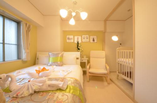 大阪River Side Namba 401的儿童卧室配有婴儿床和婴儿床