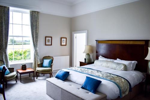 特伦特河畔伯顿德威克利夫豪尔酒店的一间卧室配有一张带蓝色枕头的大床