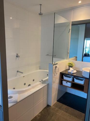 曼哲拉Dolphin View 404的白色的浴室设有浴缸和水槽。