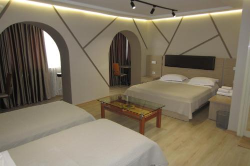 地拉那弗雷迪酒店的酒店客房设有两张床和一张桌子。