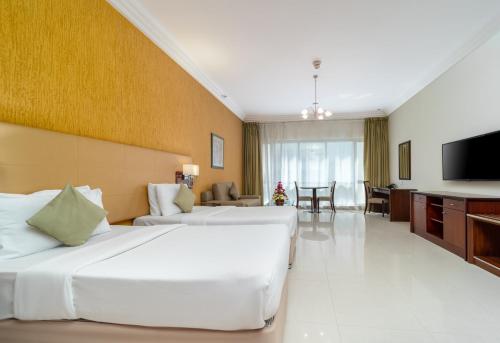 迪拜德拉星光大都市公寓酒店的酒店客房设有两张床和一台平面电视。