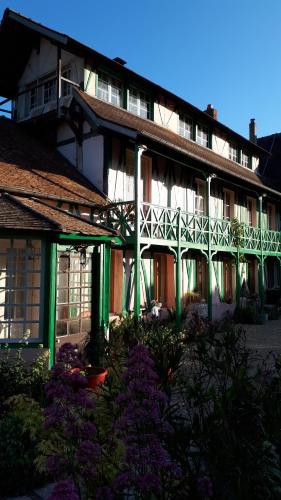 Saint-Pierre-dʼAutilsLe Jardin des Merveilles的一座绿色白色装饰和紫色花卉的建筑