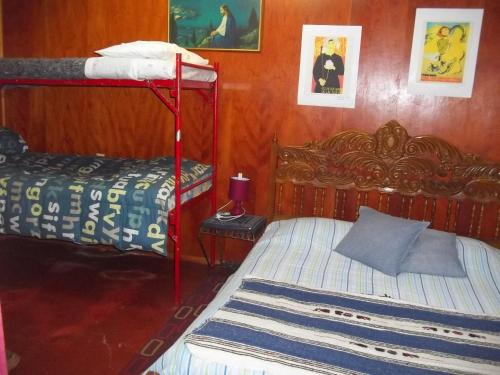 瓦尔帕莱索阿曼多旅馆 的一间卧室设有两张双层床和一张带枕头的床。