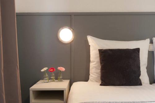 法尔肯堡杜普伊斯酒店的一张带黑色床头板的床和一张带鲜花的桌子